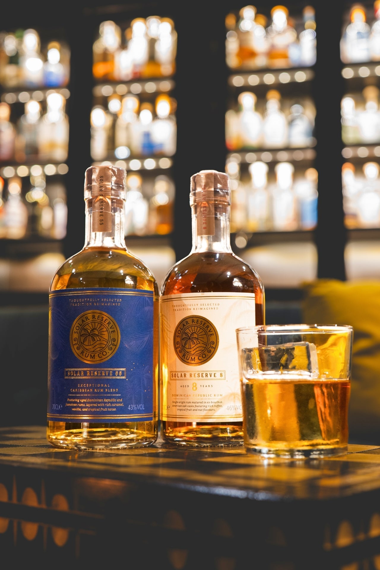 Solar Reserve 55 Rum and Solar Reserve 8 Year Old single origin poured into a glass with bar background